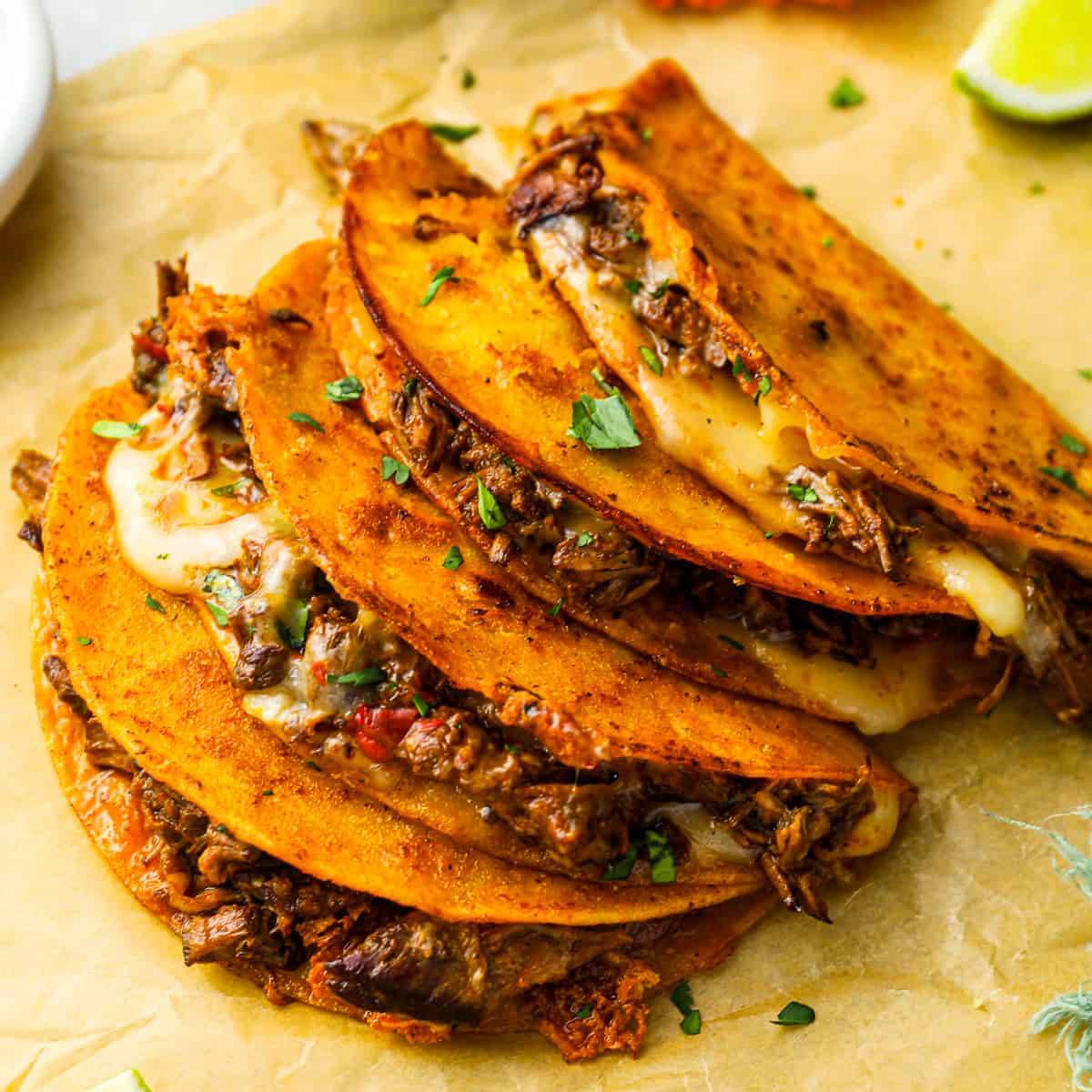 Quesabirria tacos with melted cheese and birria consomé at El Taco Chingon Fresno